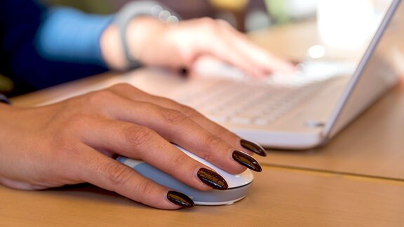 Frauenhand mit Computermaus