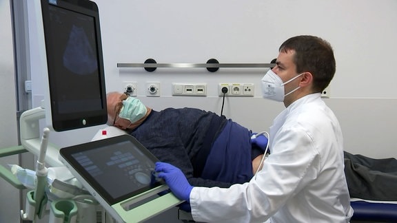 Ein ältere Mann wird am Unterleib per Ultraschall untersuch.