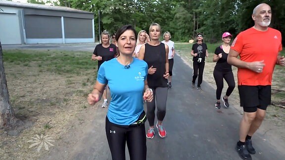 Slowjogging-Trainerin mit Laufgruppe beim Training