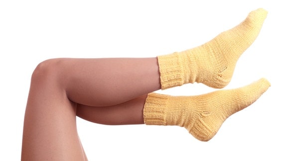 Frauenbeine, an den Füßen gelbe Socken