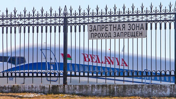 EIne Maschine der weißrussischen Gesellschaft Belavia steht hinter einem Metallzaun auf dem Flughafen von Minsk.