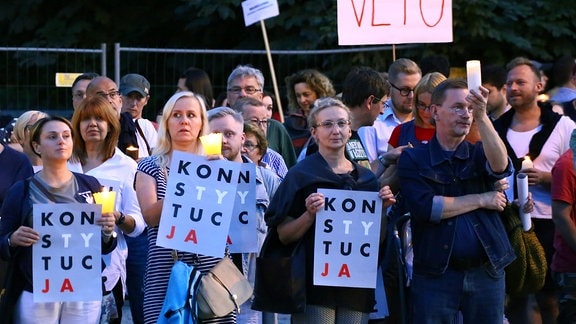 Demonstranten gegen eine umstrittene Justizreform versammeln sich am 22.07.2017 in Warschau (Polen) am Krasi_ski-Platz vor dem Obersten Gericht und halten angezündete Kerzen und Plakate (l) mit dem Schriftzug «Verfassung» hoch. 