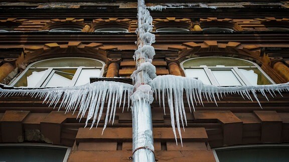 Eiszapfen hängen an einer Dachrinne
