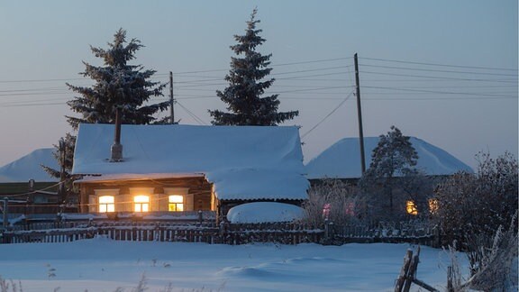 Häuser in Winterlandschaft bei Nacht.