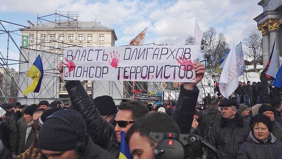 Ein Transparent mit dem Schriftzug "Die Macht der Oligarchen ist Sponsor der Terroristen"