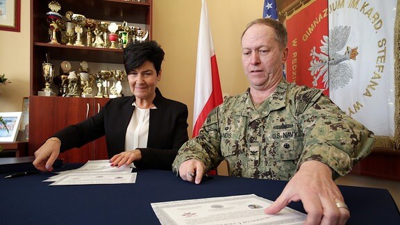 Schulleiterin Elżbieta Domańska und US-Captain Chris Landis bei Unterzeichnung eines Partnerschaftsvertrages.