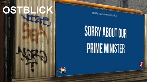 "Sorry about our Prime Minister" steht auf einer blauen Werbetafel