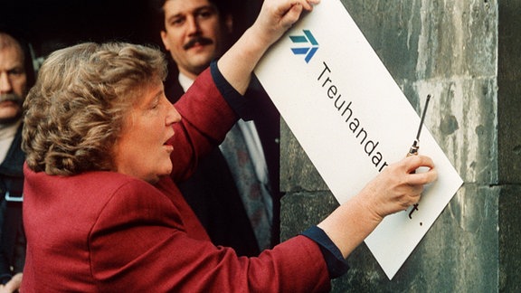 Birgit Breuel entfernt am 30.12.1994 mit einem Schraubenzieher das Firmenschild am Eingang der Treuhandanstalt in Berlin