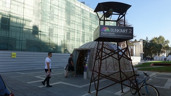 Wachturm mit der Aufschrift „Bunk’art 2“ vor dem Eingang zum Museum in einem nachgebildeten Bunker.