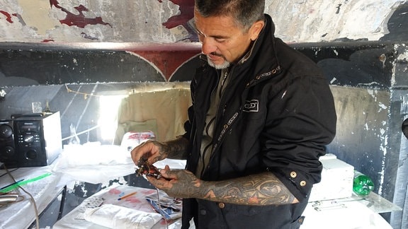Tattoo-Künstler Keq Marku zeigt eine Tattowier-Nadel im Inneren seines Bunkers nahe der Ortschaft Koplik in Nordalbanien.
