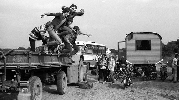 Feierabend - Jugendliche springen von einem Hänger nach ihrem Einsatz während der Kartoffelernte der LPG Dahme, 1982