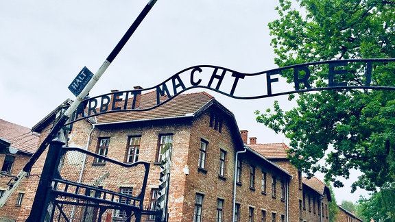 Die Gedenkstätte in Auschwitz mit Toraufschrift ARBEIT MACHT FREI