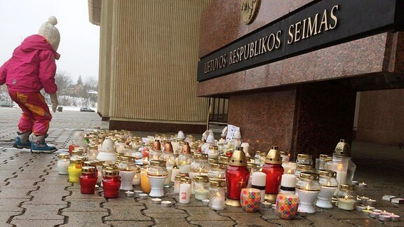 Kerzen zum Gedenken stehen vor einem Gebäude.