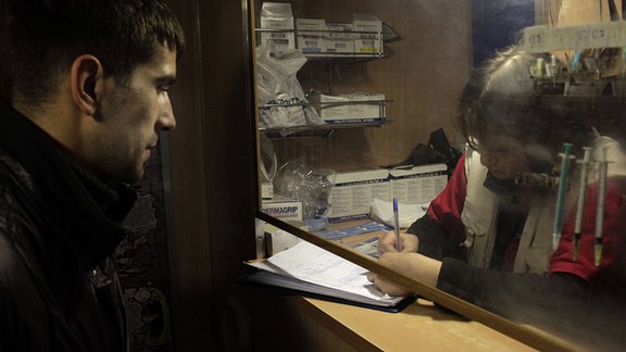 Ein Heroinsüchtigen tauscht Spritzen an einem Nadelaustausch Schreibtisch in St.Petersburg, Russland.