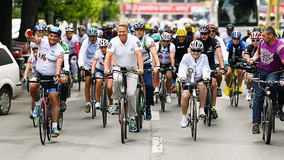 Rumänischer Präsident Klaus Iohannis auf dem Fahrrad (M).