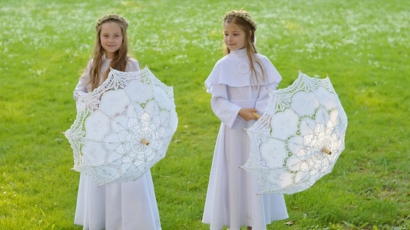 Mädchen in weißen Kleidern freuen sich auf ihre Erstkommunion in Polen 