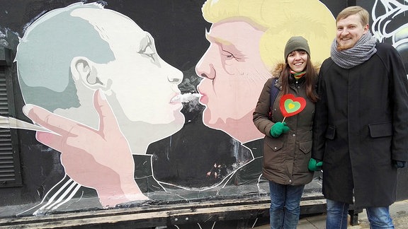 Litauischer Comedian Paulius Ambrazevičius mit Freundin vor dem Putin-Trump-Graffiti in Vilnius.