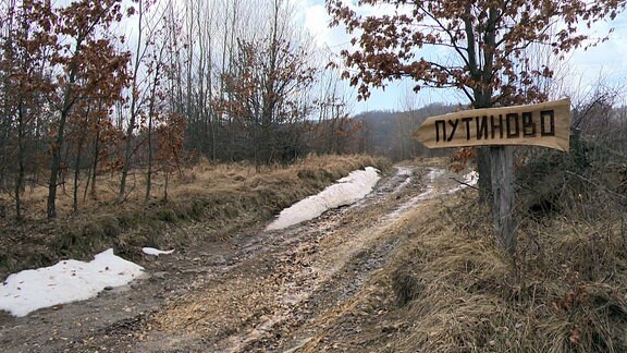 Das Ortsschild, das den Weg zum Dorf Putinovo weist.