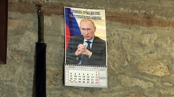 Ein Kalender mit dem Portrait Putins hängt an der Wand der Dorfkneipe. 