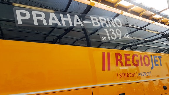 gelber RegioJet-Bus mit aufgeklebter Werbung für Tickets von Prag nach Brünn