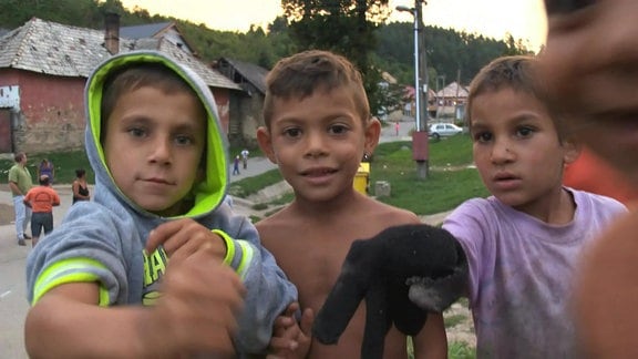 Vier Roma-Kinder im Freien posieren
