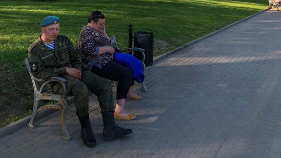 Soldat sitzt in Park vor Kirche