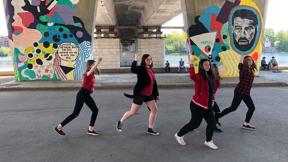 Jugendliche tanzen unter einer Brücke