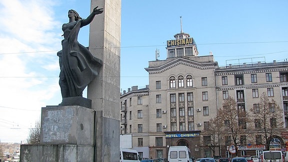 Ein großes , mehrgeschossiges Wohnhaus im stalinistischen Baustil. Davor ein Denkmal für die Gefallenen des "Großen Vaterländischen Krieges".