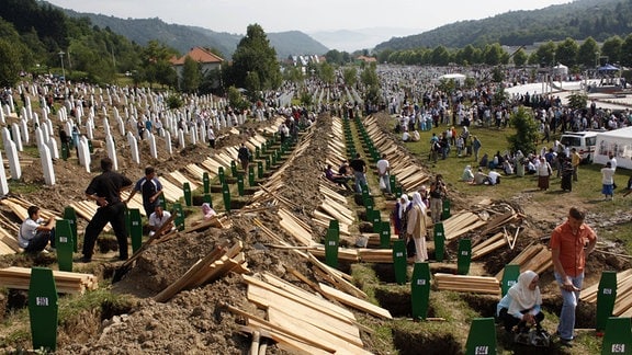 Zehntausende Menschen auf einem Friedhof wollen ihre Angehörigen beerdigen.