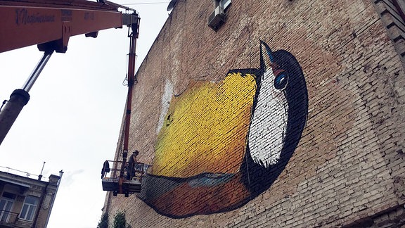  Ein Vogelgraffiti an einer alten Mauer.