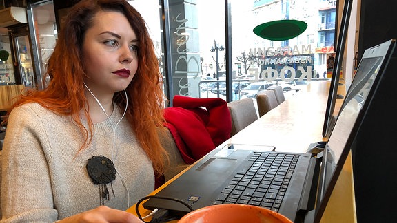 Eine junge Frau vor einem Laptop