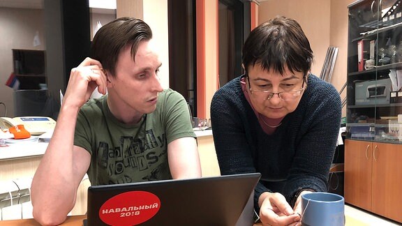 Eine Frau und ein junger Mann vor einem Laptop