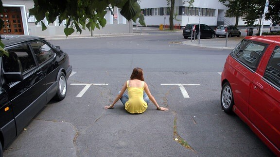 Eine Frau hält einen Parkplatz besetzt