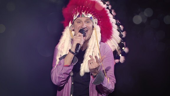 Der Sänger von Pur singt und trägt Indianer Federschmuck