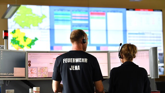 Mitarbeiter stehen in der Zentralen Leitstelle im Gefahrenabwehrzentrum Jena. 