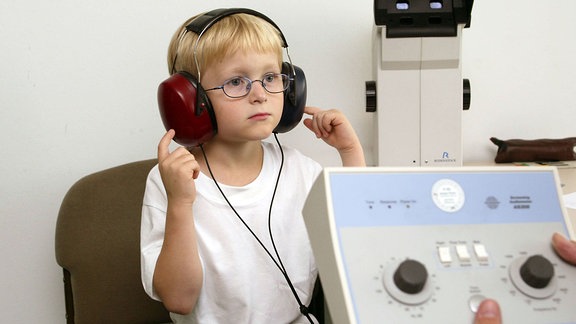 Ein Kind macht den Hörtest zur Einschulungsuntersuchung