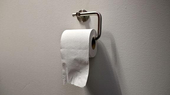  Eine Rolle Toilettenpapier hängt in einem Halter.