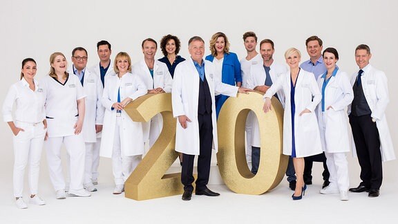 Das Team der Sachsenklinik posiert mit einer "20" zum Jubiläum der Serie.