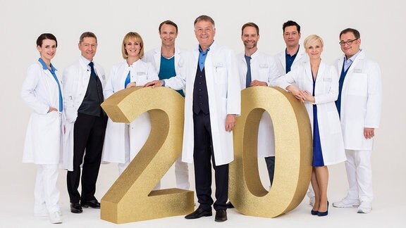 Das Team der Sachsenklinik posiert mit einer "20" zum Jubiläum der Serie.