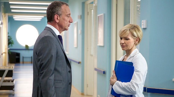 Zwischen Alexander Weber (Heio von Stetten) und Dr. Kathrin Globisch (Andrea Kathrin Loewig) sprechen im Krankenhausflur.
