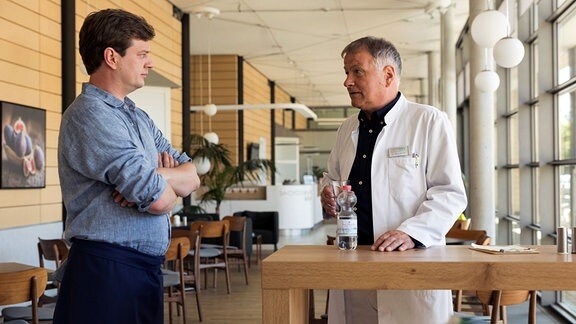  Vater und Sohn – Jakob und Roland Heilmann stehen in der Cafeteria der Sachsenklinik an einem der kleinen Stehtische.