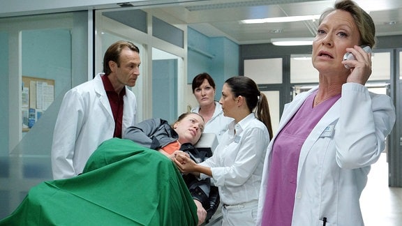 Oberschwester Arzu, Dr. Stein und eine Gynäkologin kümmern sich um eine Patientin