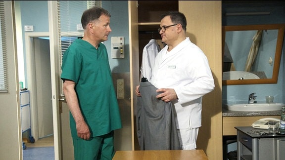 Als Dr. Roland Heilmann (Thomas Rühmann, li.) aus einer Notoperation an Olaf Beck kommt, muss er den Pfleger Hans-Peter Brenner (Michael Trischan, re.) etwas trösten.