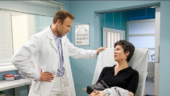 Dr. Martin Stein steht am Krankenbett von Dr. Elena Eichhorn.