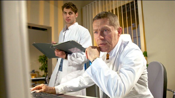 Dr. Kaminski (Udo Schenk, re.) glaubt, herausgefunden zu haben, warum Dr. Niklas Ahrends (Roy Peter Link, li.) Patientin vehement auf ihrer Selbstdiagnose besteht und jede weitere Untersuchung verweigert.