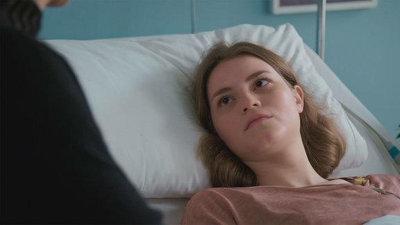 Eine junge Frau in einem Krankenbett