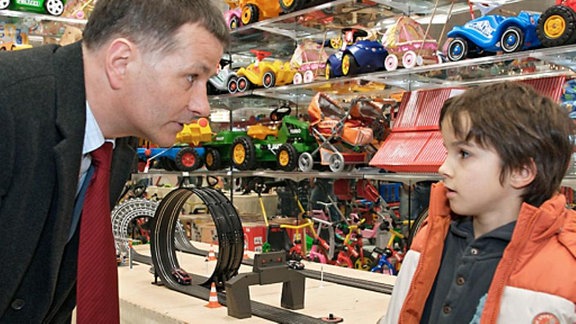 Roland geht mit seinem Enkel Jonas in einen Spielzeugladen.
