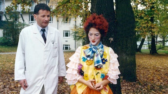 Dr. Roland Heilman (Thomas Rühmann) spricht mit Uta Ernst (Margit Satorius), die mit der Clown-Therapie  zum Heilungsprozeß der Kinder durch Lachen beitragen möchte. Dabei hat Uta selbst einen bösartigen Gehirntumor...