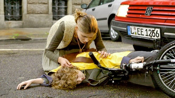 Der 12-jährige Jens (Moritz Mack) ist in ein Auto gelaufen und liegt bewusstlos auf der Straße. Seine Mutter Sibylle Wolter (Alexandra Finder) kümmert sich um ihren verletzten Sohn und veranlasst ärztliche Hilfe.