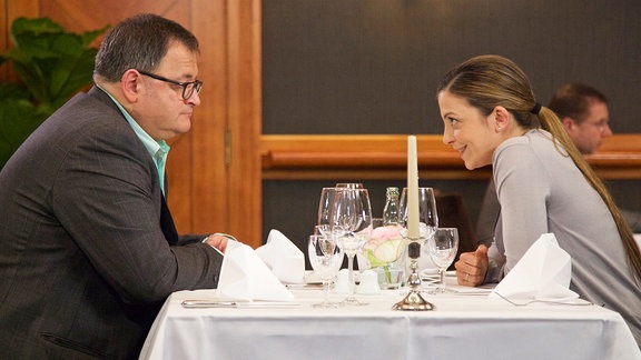 Arzu Ritter (Arzu Bazman) unterhält sich mit Hans-Peter Brenner (Michael Trischan) in einem Restaurant.